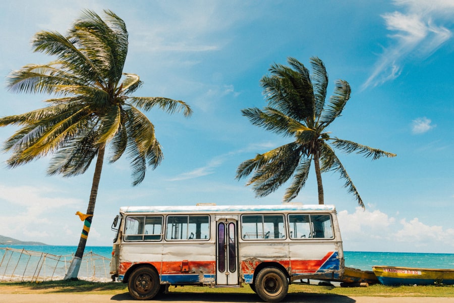 best time to travel to Jamaica and how to prepare - blog - Tropical scene in Jamaica showing a bus at the beach